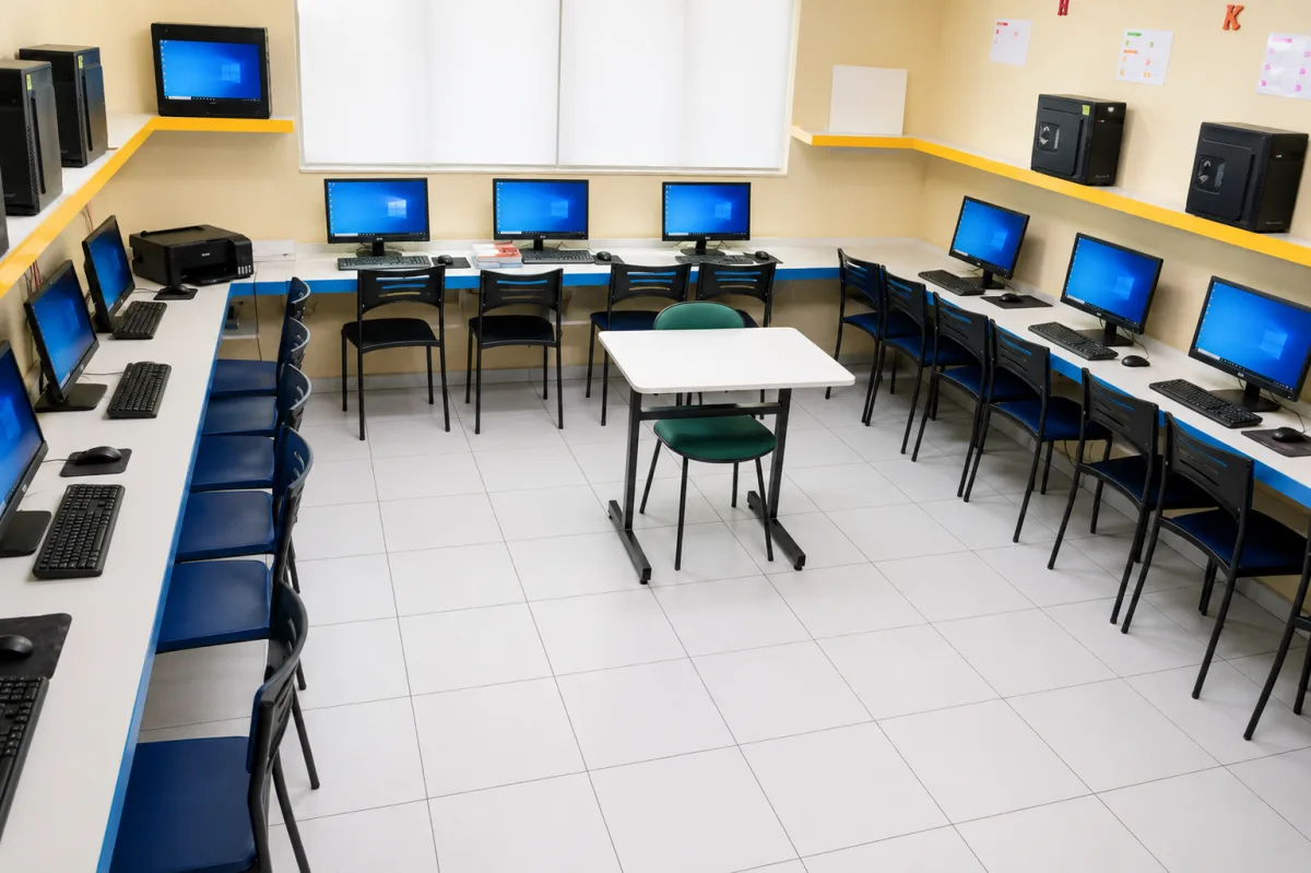 Laboratório de informática com computadores ligados
